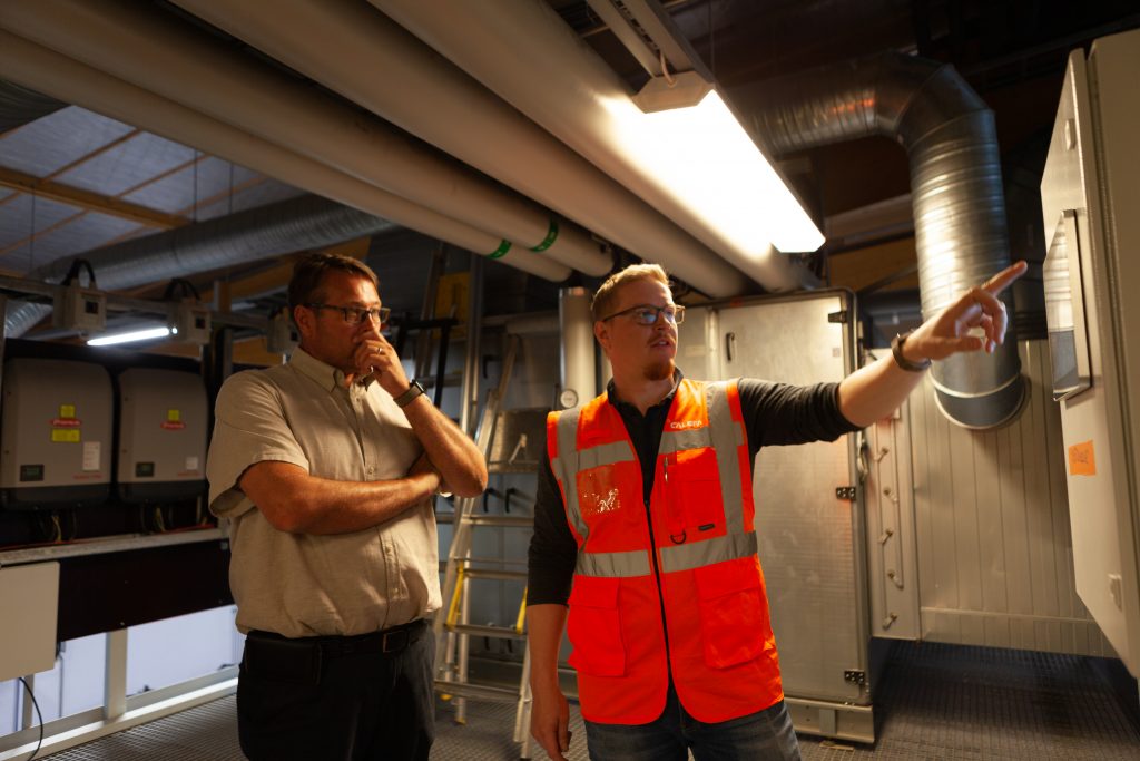 Favoritin toimitusjohtaja Kaj Paavola ja Calefan projektipäällikkö Joonas Palmi tarkastelelevat lämpöpumppujärjestelmän automaatiota.